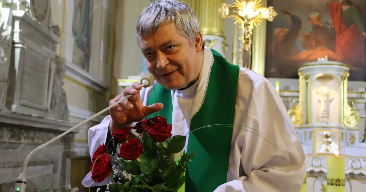 Ksiądz Piotr z bukietem róż, jak Piotr i Paweł, przemawia do wiernych w kościele.