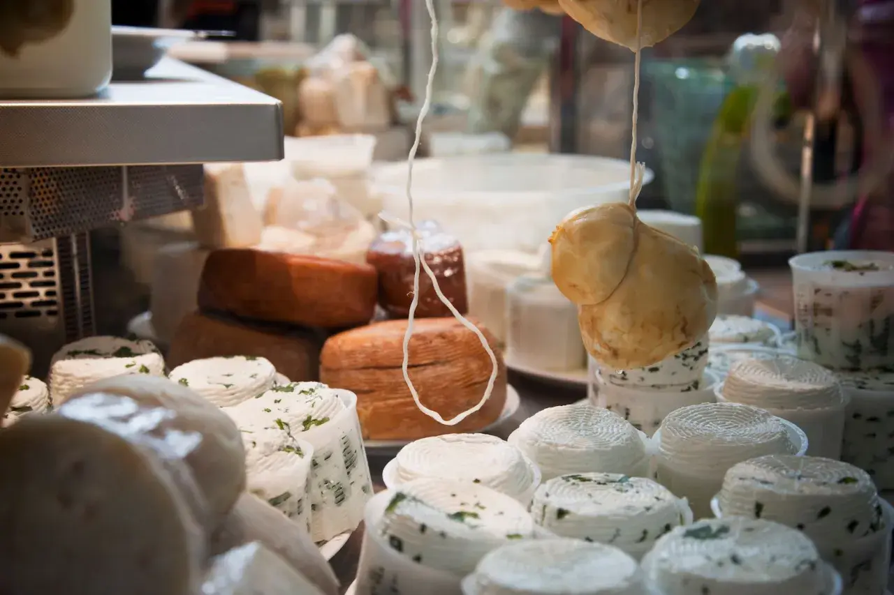 Assortimento di formaggi freschi e stagionati, tra cui spiccano i formaggi a pasta cotta, pronti per essere gustati.