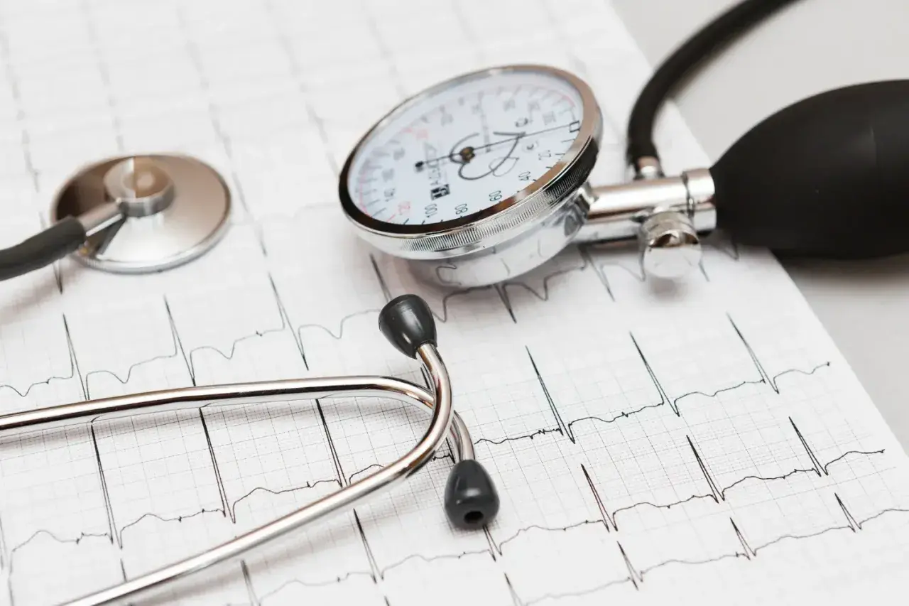 Stetoskop i ciśnieniomierz na tle EKG. Dbanie o serce, jak przyjmowanie leku Valsacor, jest kluczowe.