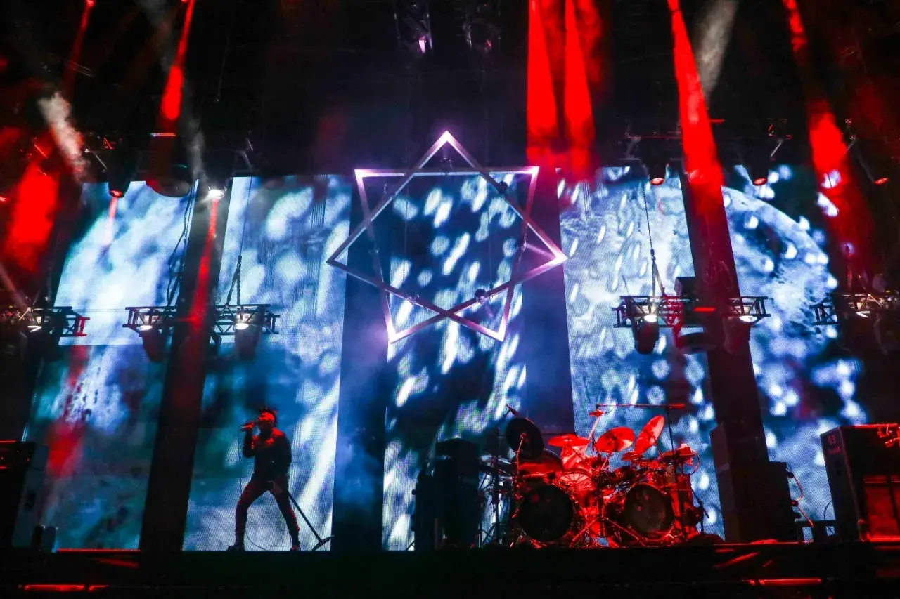 Wokalista na scenie, perkusja, wielka gwiazda na tle ekranu. Niesamowita atmosfera na **impact festival**.