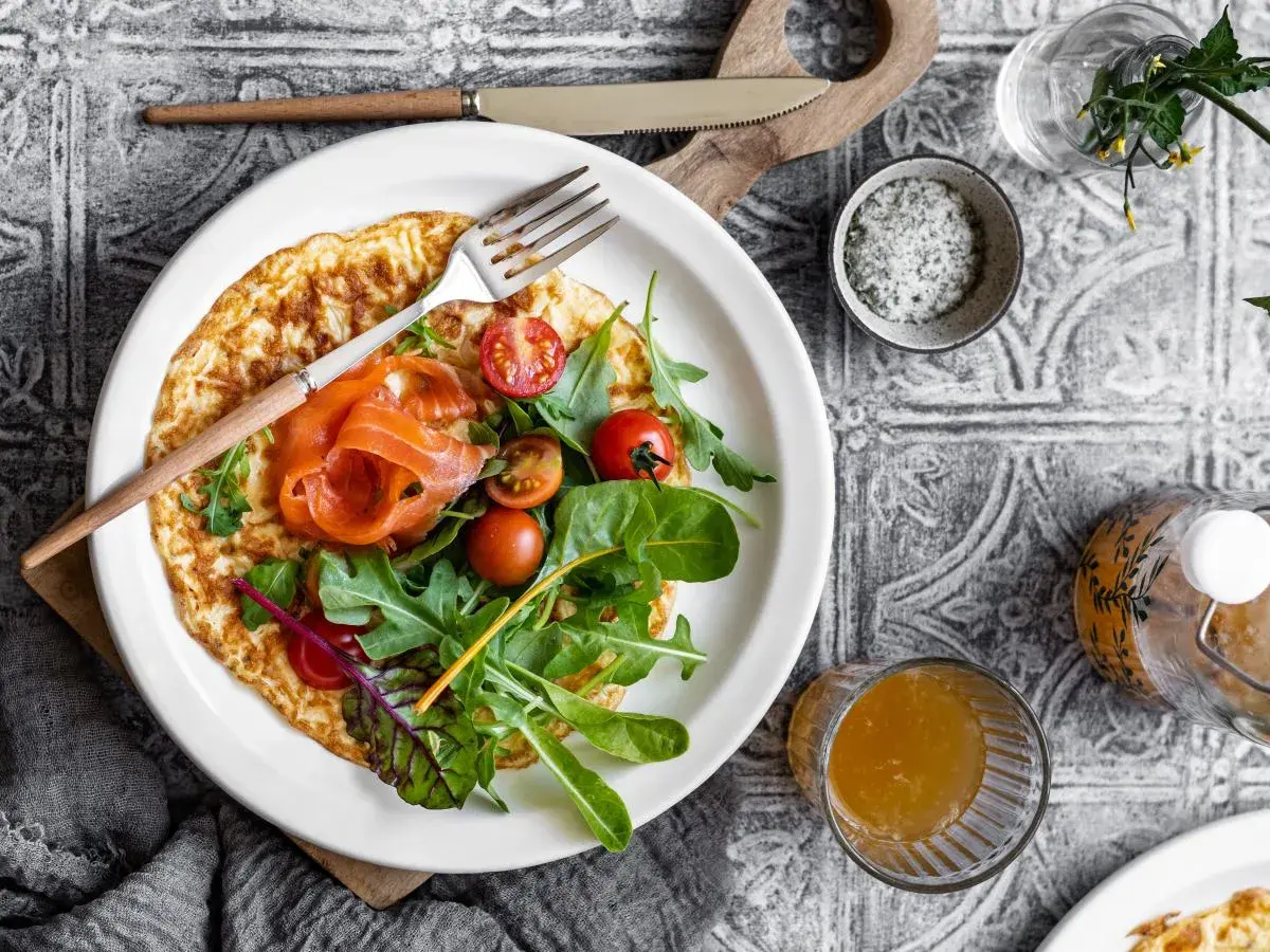 Pyszny omlet na słono z łososiem, pomidorkami i rukolą. Idealny na śniadanie lub lekki lunch.