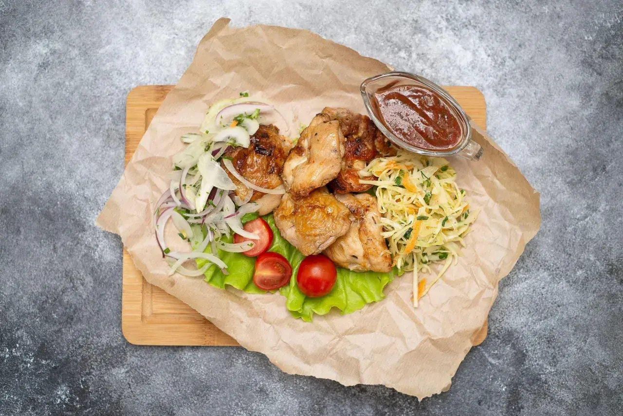 Grillowany kurczak z surówką z kapusty, cebulą, pomidorkami i sosem.