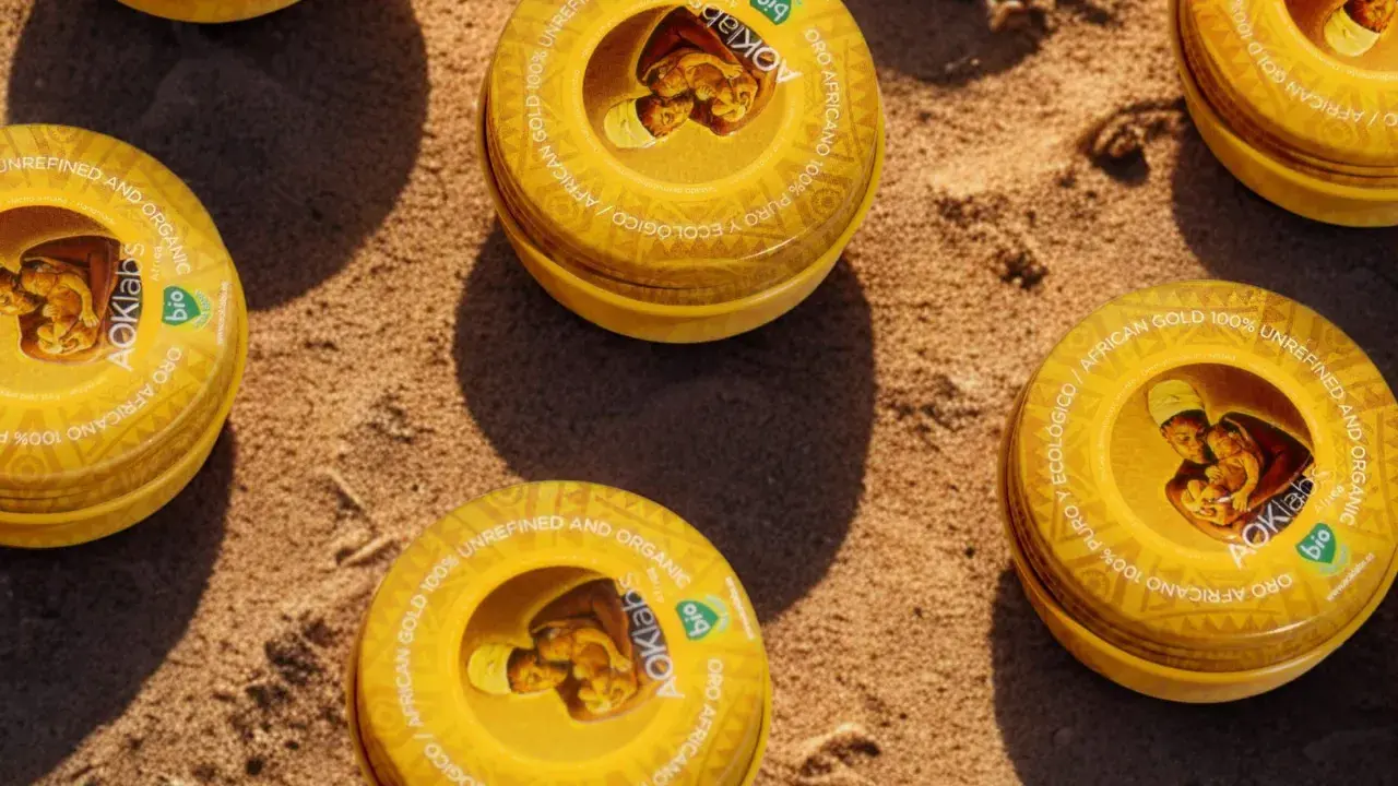 Latas de manteca de karité para el pelo, oro africano 100% puro y ecológico, sobre arena.