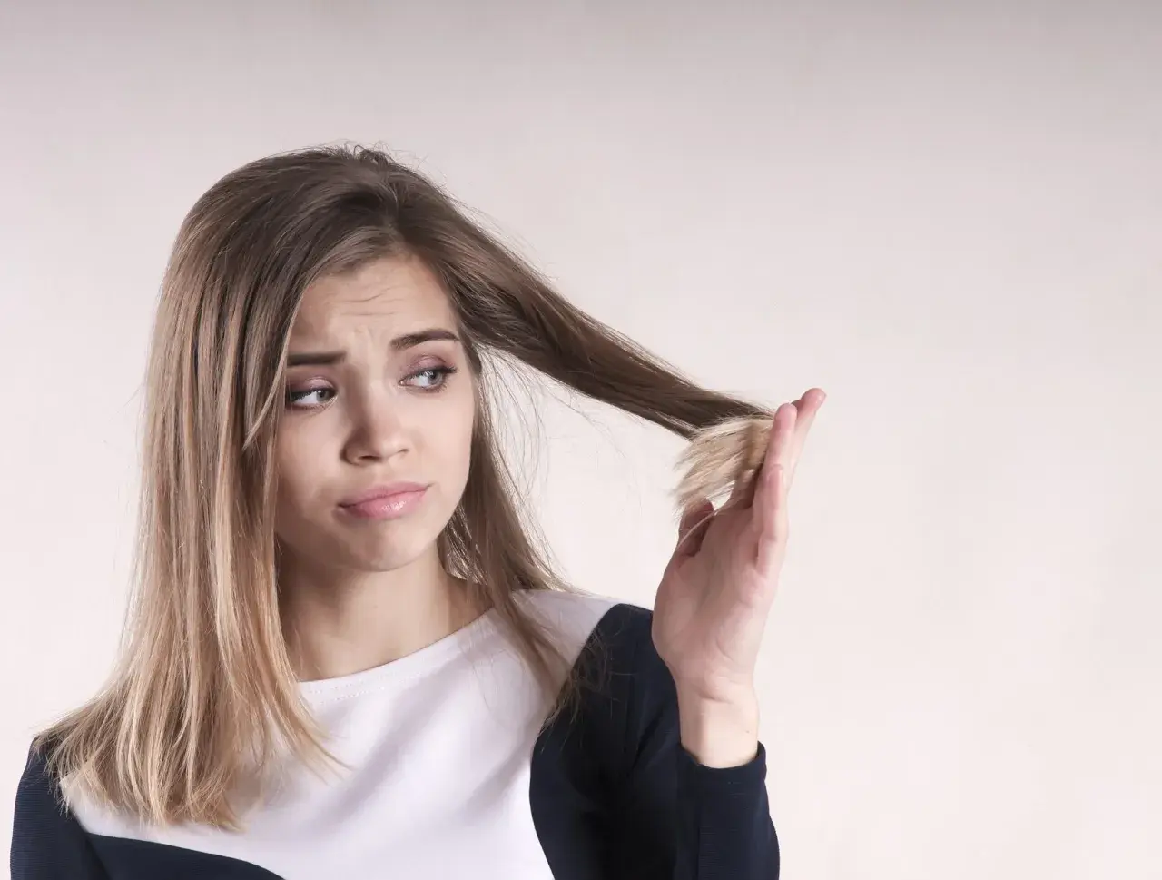 Ragazza preoccupata per le doppie punte, si chiede perché i capelli crescono lentamente.