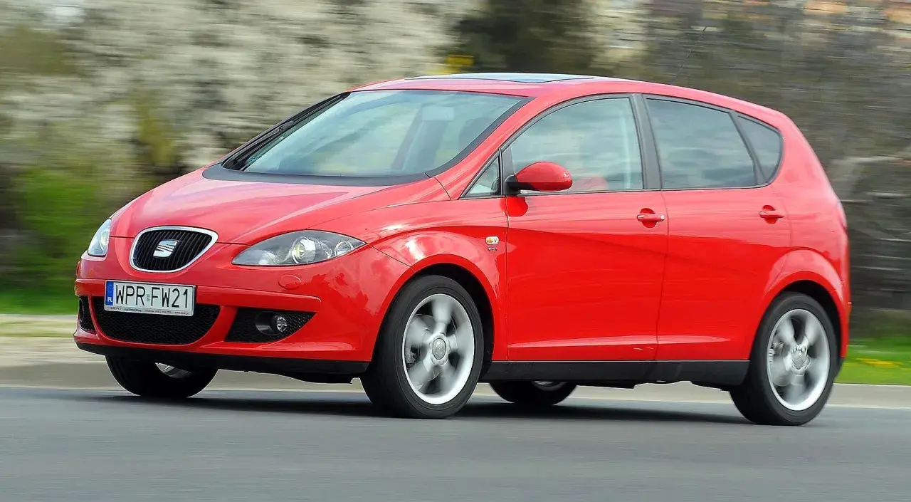 Czerwony Seat Altea 1.6 benzyna w ruchu, z rozmytym tłem.