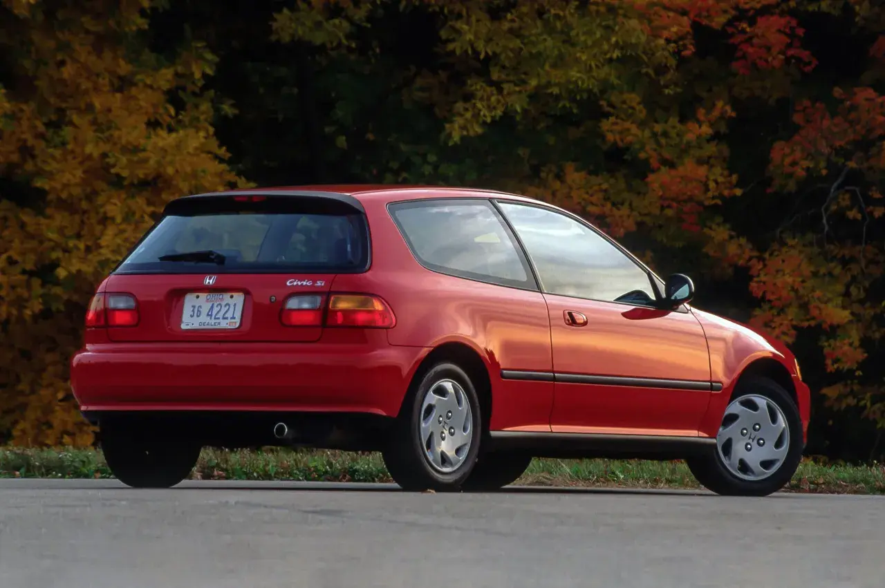 Czerwony Honda Civic Si z lat 90. na tle jesiennych drzew.
