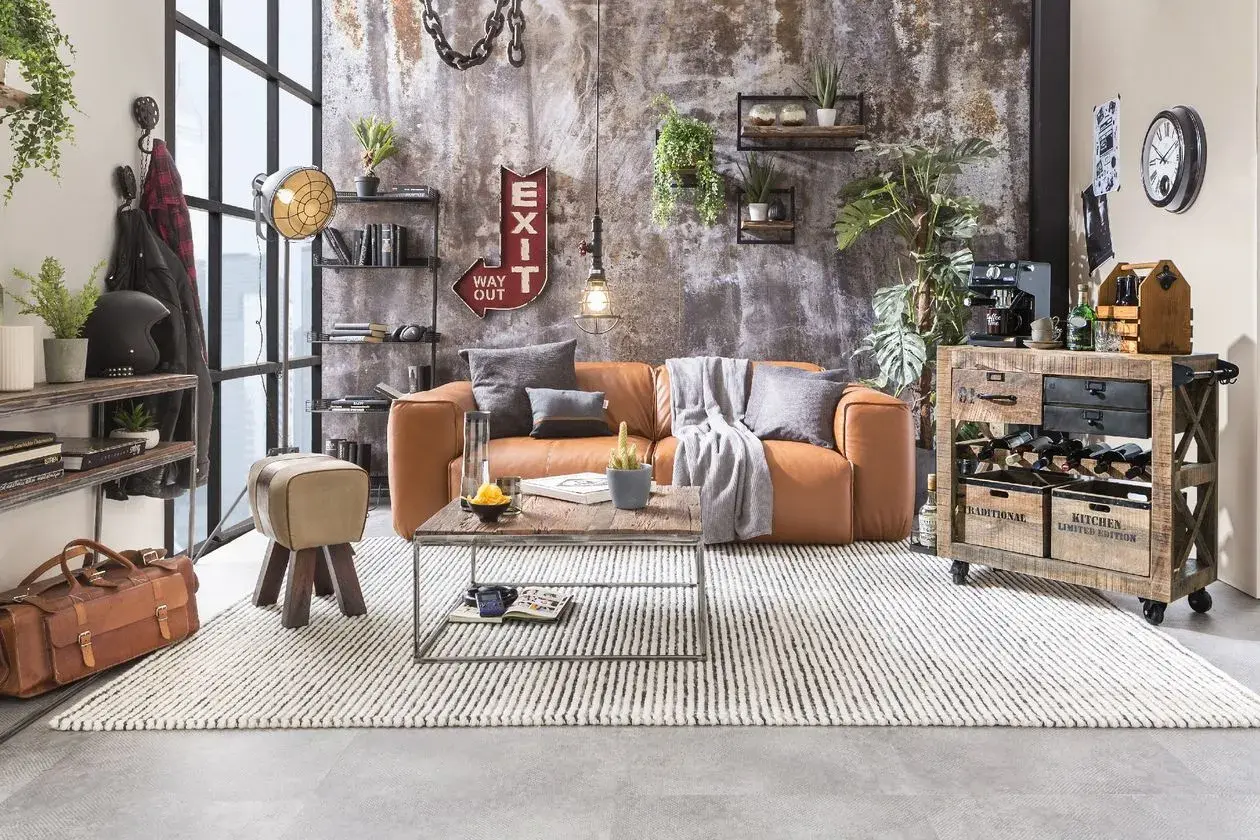Gemütliches Wohnzimmer im **retro stil** mit cognacfarbenem Sofa, Holztisch und rustikalem Weinregal.