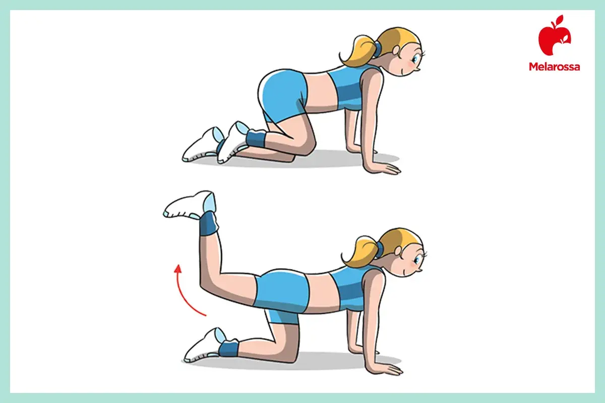 Donna in posizione quadrupedica esegue un esercizio per ottenere glutei perfetti. Solleva una gamba all'indietro.