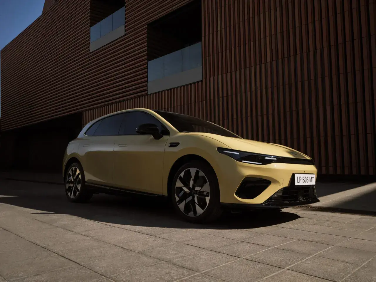 La Leapmotor A05, un'auto elettrica dal design moderno, è parcheggiata davanti a un edificio con facciata a listelli.