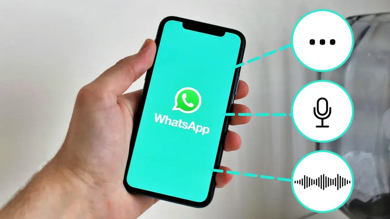 Mano sostiene un teléfono con WhatsApp. Iconos de puntos suspensivos, micrófono y onda sonora sugieren funciones, como "que significa gn en inglés".