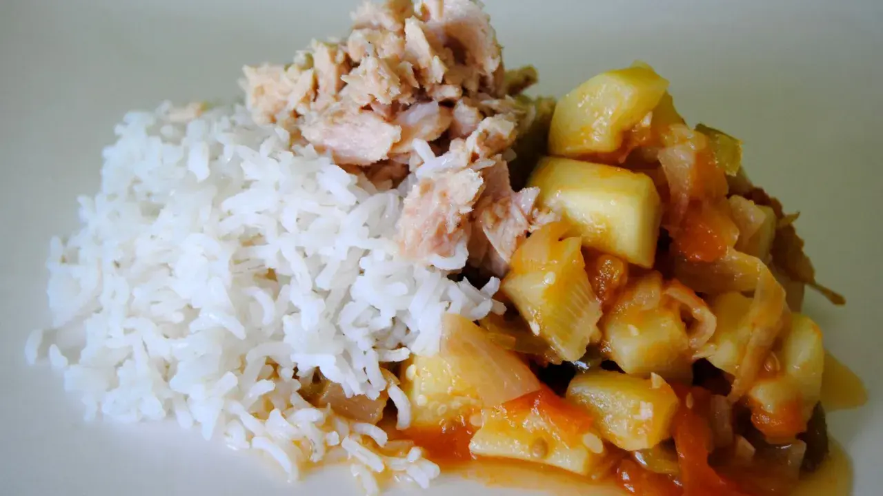 Arroz blanco con trozos de bonito de lata desmenuzado y un guiso de verduras en salsa de tomate.