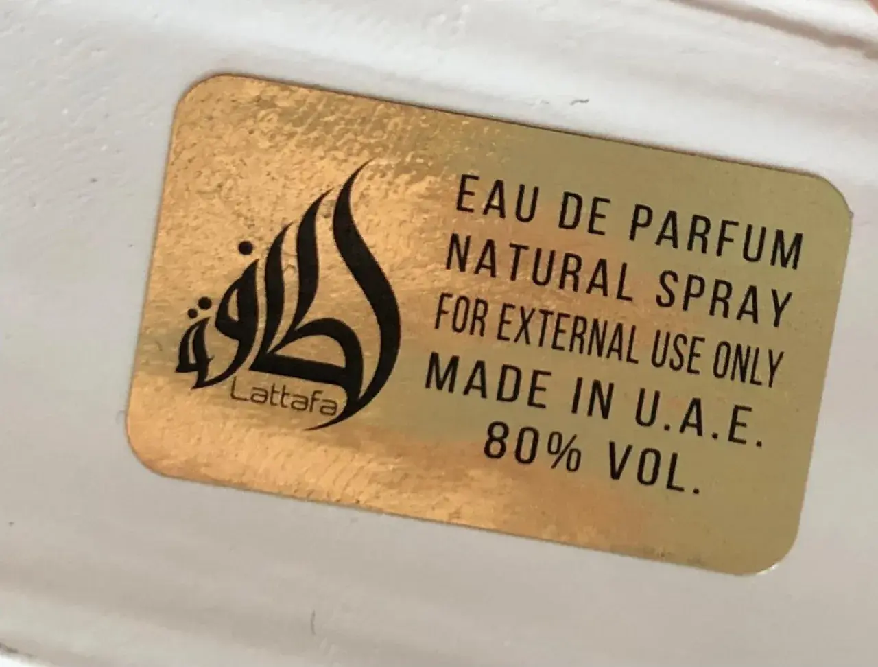 Złota naklejka z napisem Lattafa i logo. Woda perfumowana, spray naturalny, do użytku zewnętrznego, wyprodukowano w ZEA. Qaed Al Fursan Unlimited.