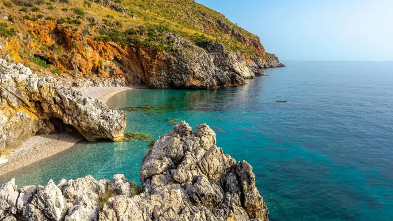 Una caletta nascosta con acque cristalline e rocce imponenti, un gioiello tra le **best beaches in Sicily**.