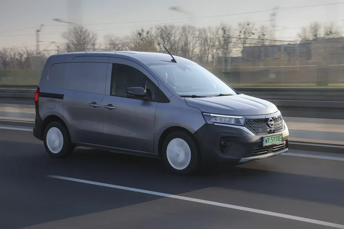 Szary Nissan Townstar pędzi autostradą, gotowy do transportu ładunków.