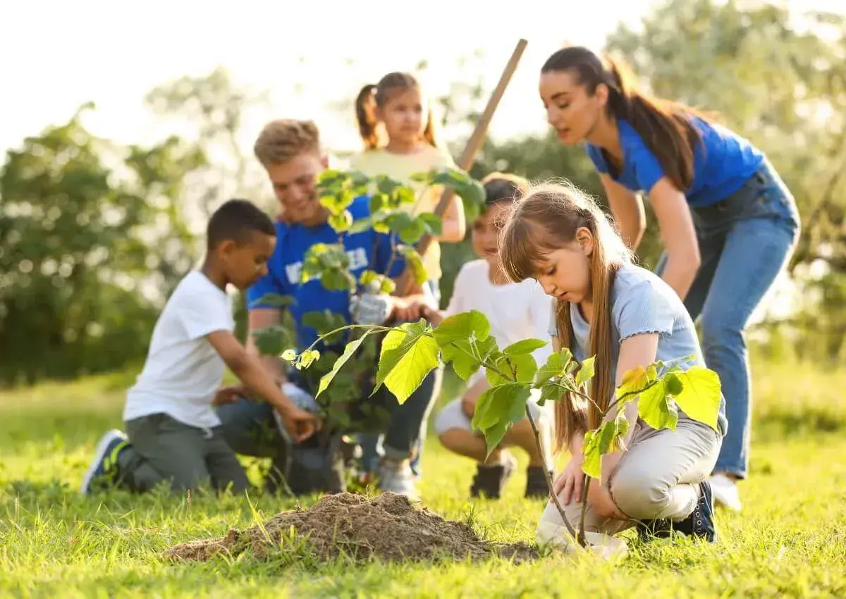 Kinder pflanzen Bäume im Rahmen eines Projekts zum Umweltschutz im Kindergarten.