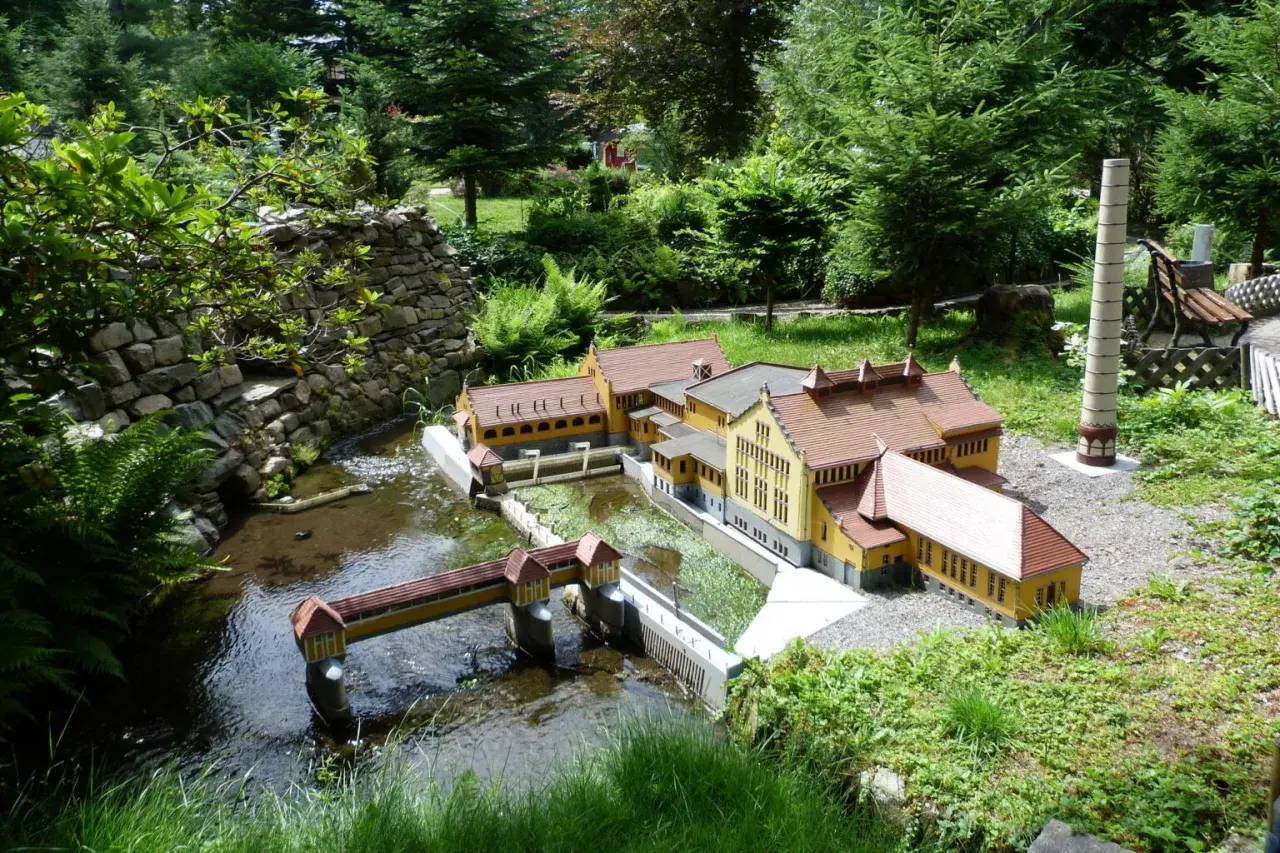 Miniaturowa zabudowa z mostkiem i rzeką, część największego parku miniatur w Polsce.