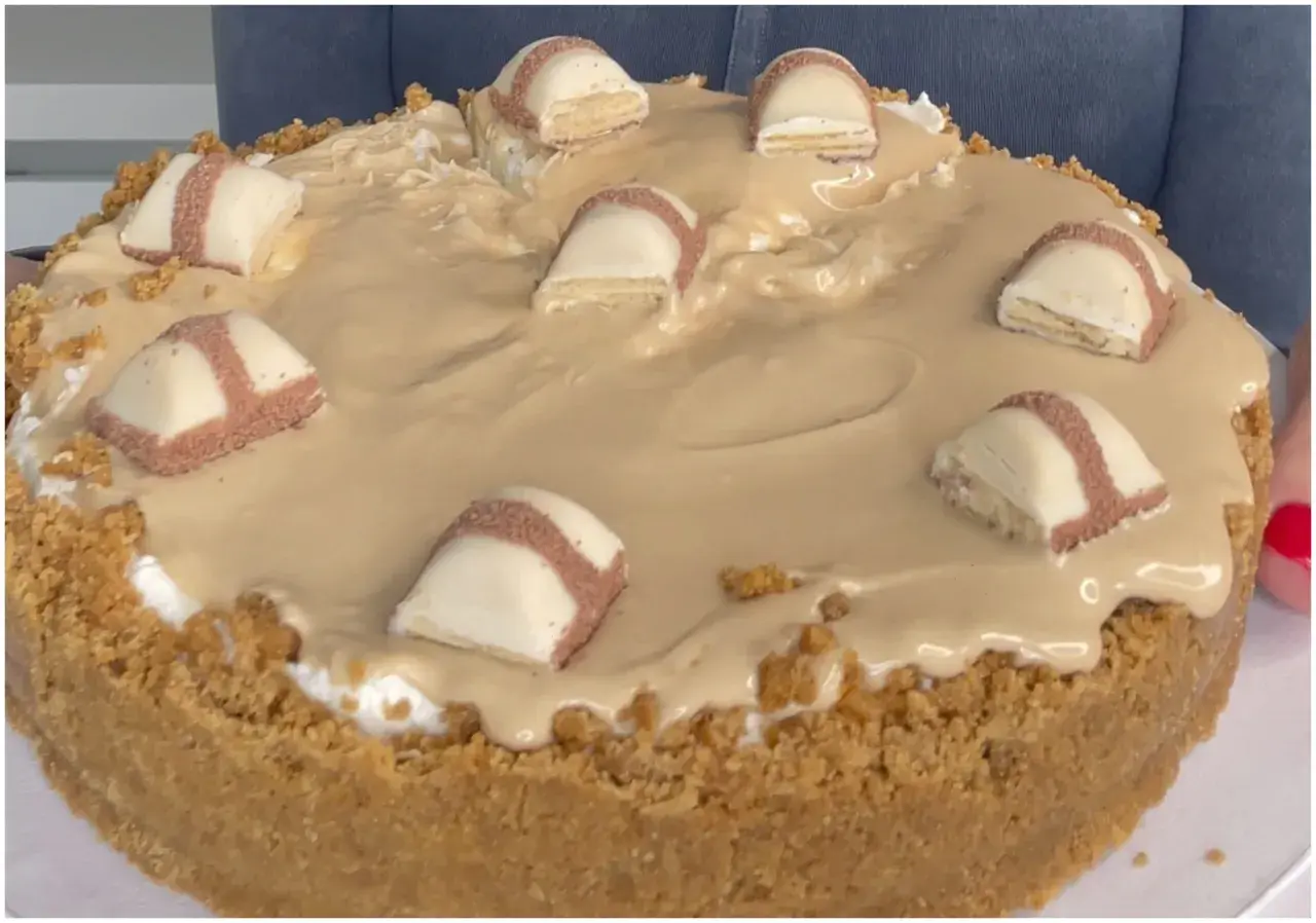 Cheesecake con copertura cremosa e pezzi di Kinder Bueno, un dolce irresistibile per gli amanti del cioccolato.