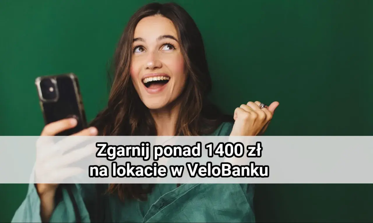 Uśmiechnięta kobieta trzyma telefon, a na ekranie widnieje napis "Zgarnij ponad 1400 zł na lokacie w VeloBanku".