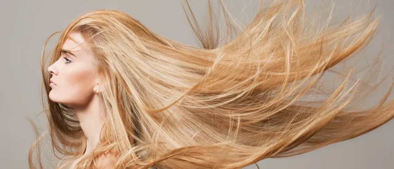 Mujer rubia con el pelo largo y suelto que parece que el pelo se aclara con el sol.