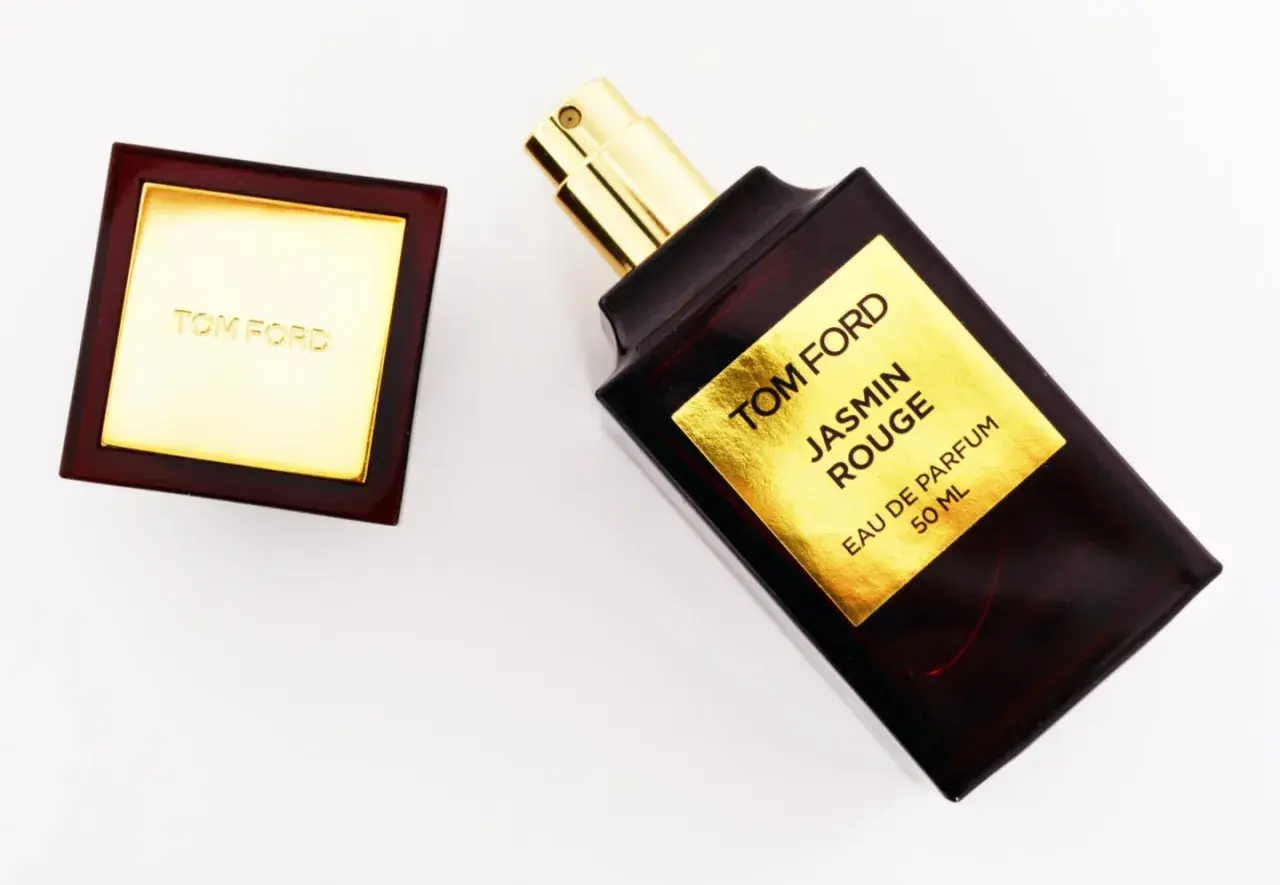 Elegancka butelka perfum Tom Ford Jasmin Rouge z złotą etykietą i korkiem.