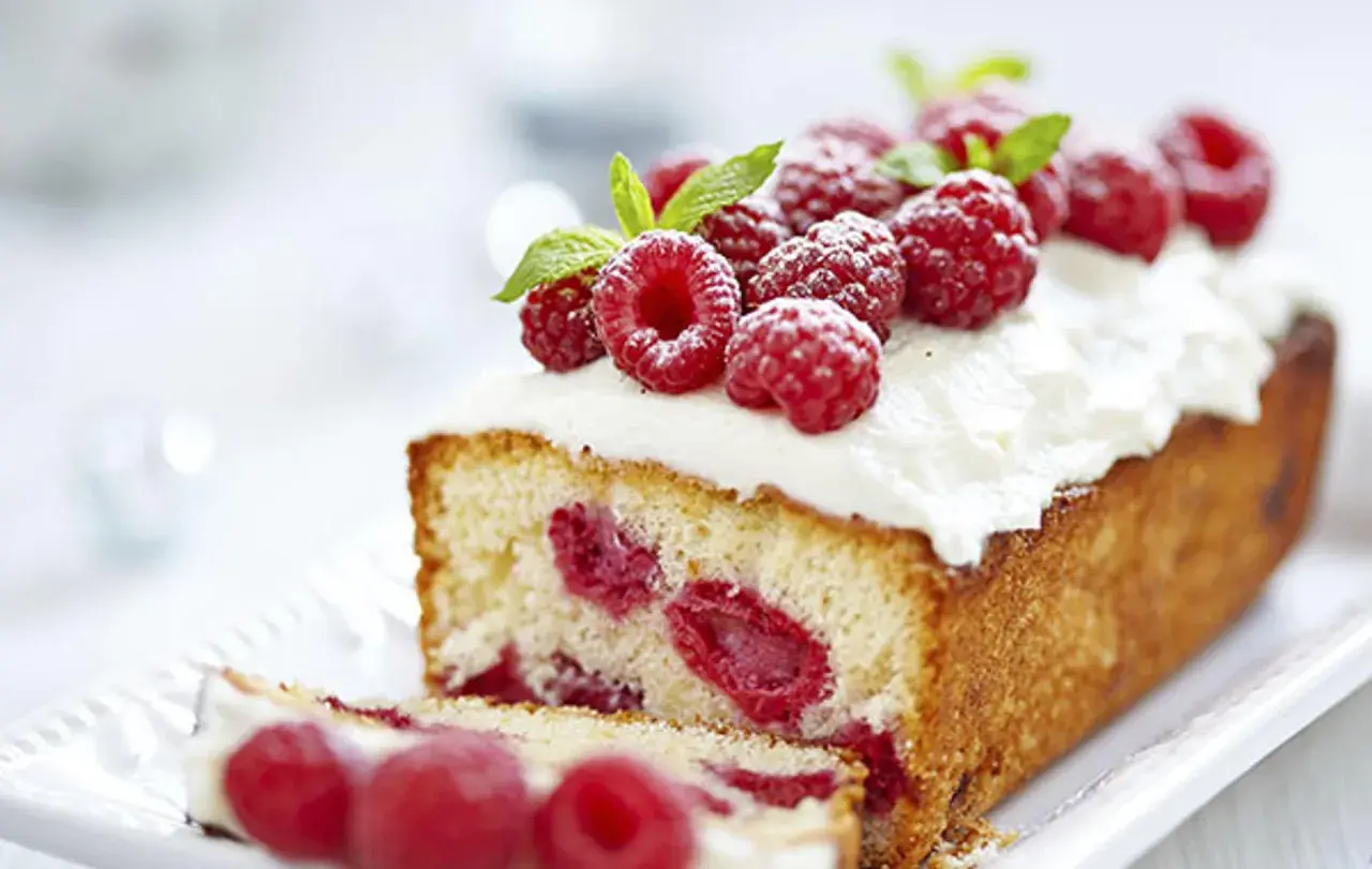 Un délicieux framboisier gateau, garni de framboises fraîches et de crème fouettée, prêt à être dégusté.