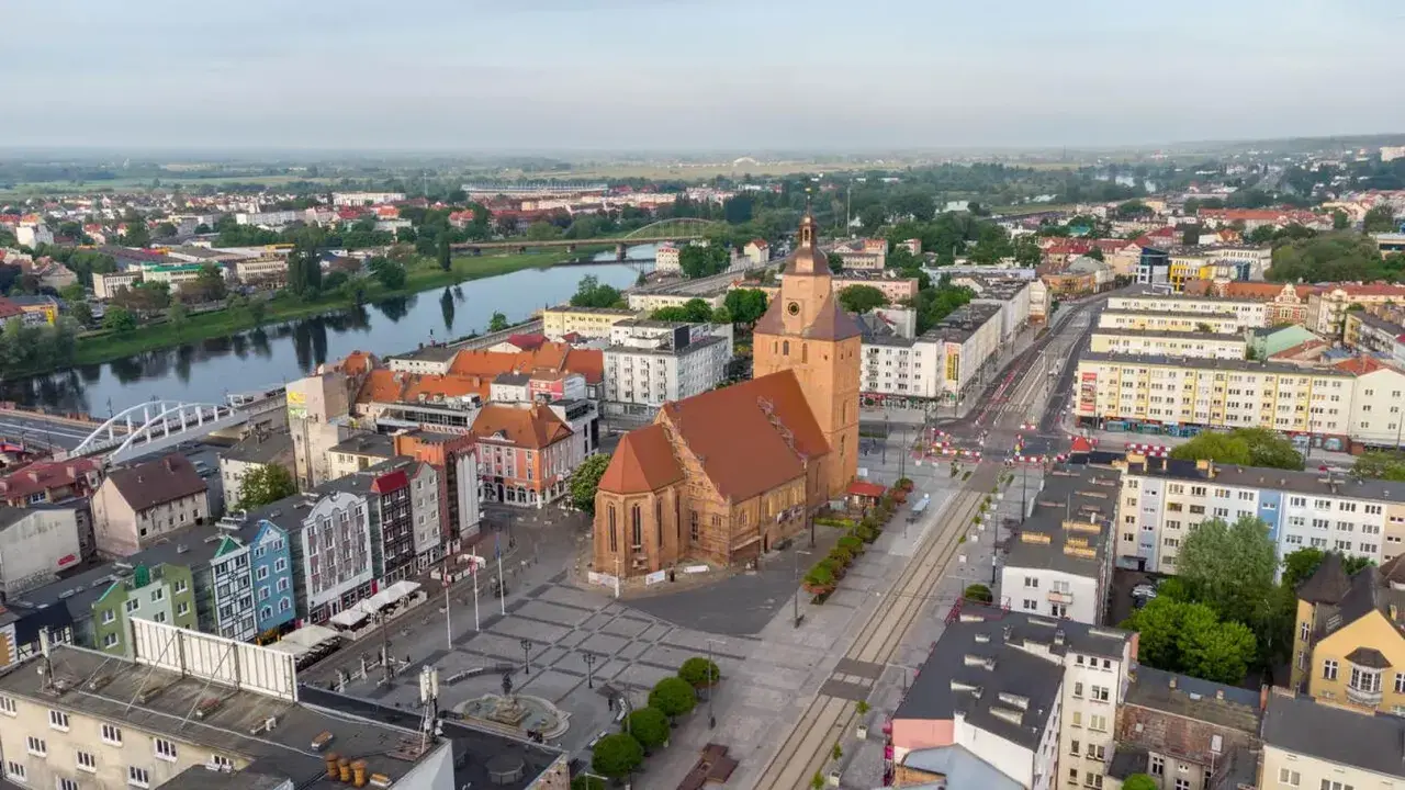 Gorzów Wielkopolski atrakcje dla dzieci: malowniczy widok na miasto z rzeką, kościołem i kolorowymi kamienicami. Idealne miejsce na rodzinne wycieczki.