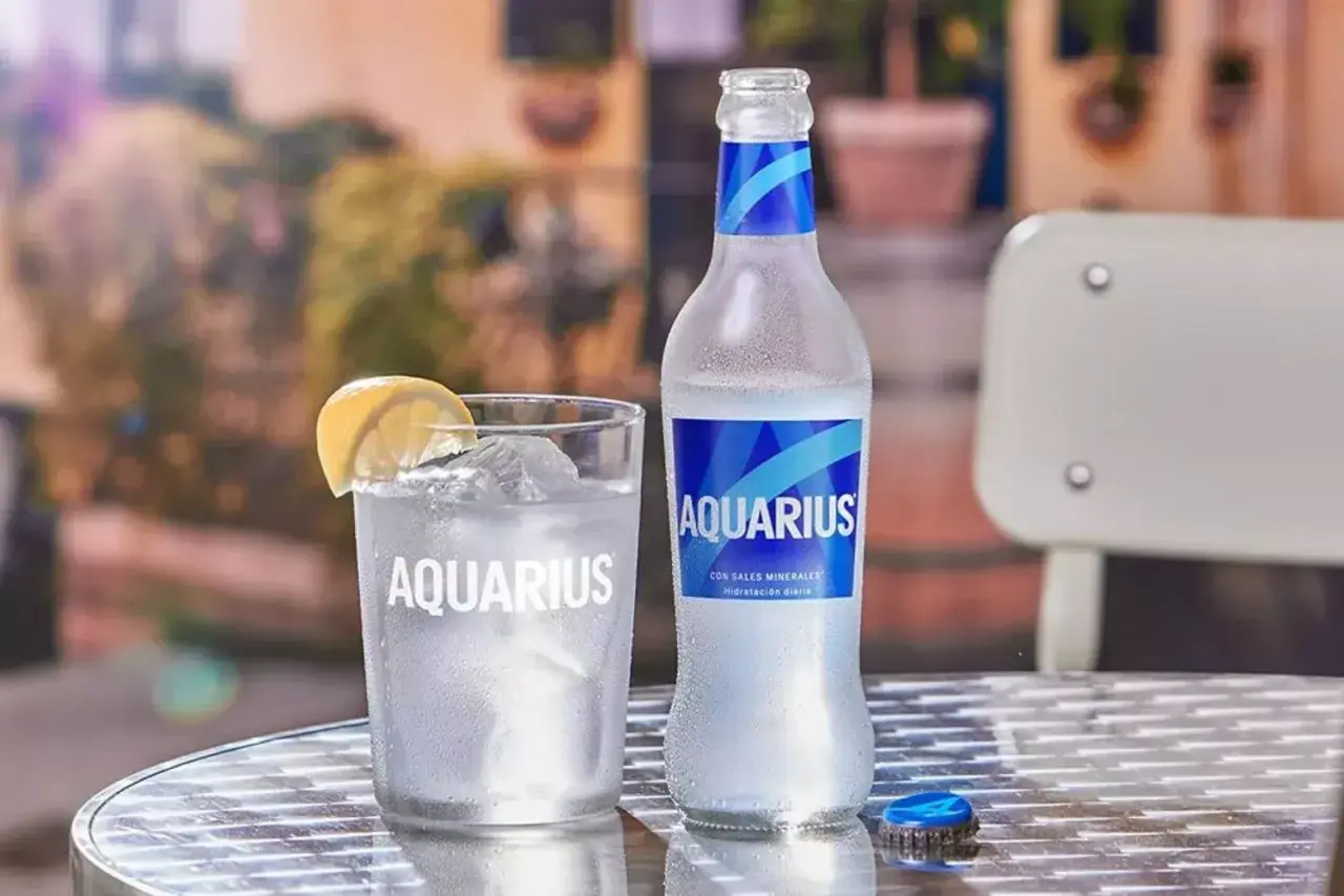 Un vaso y una botella de Aquarius con limón y hielo. Es bueno el Aquarius para los niños, ideal para hidratarse.
