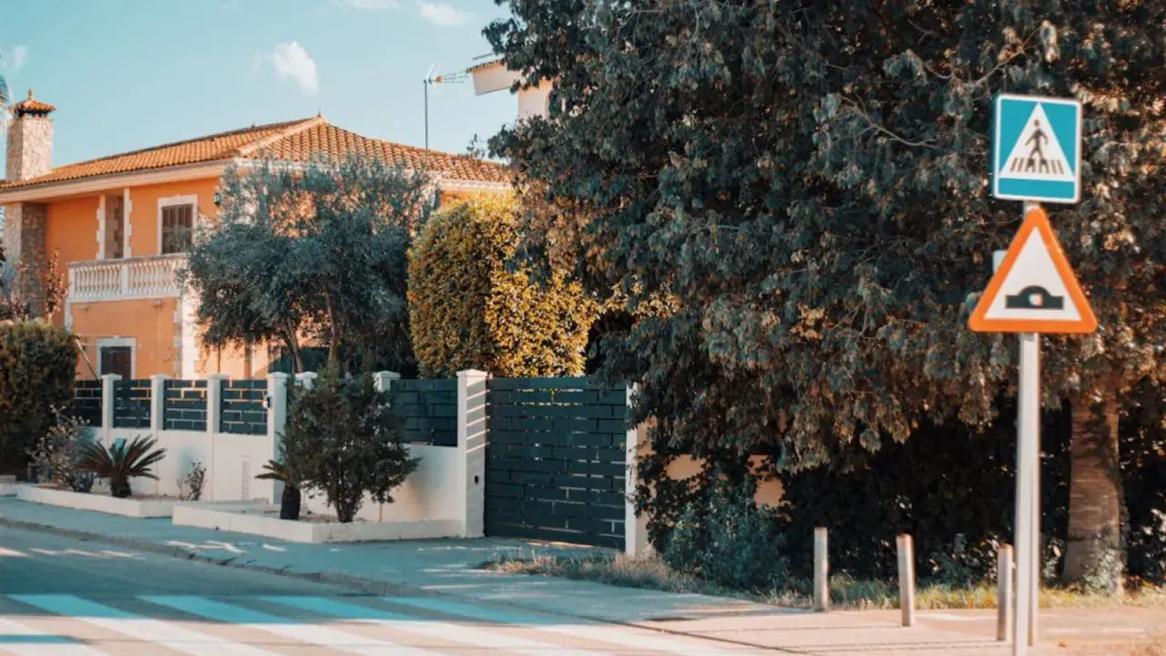 Panneau de passage piétons et ralentisseur. La question "un particulier peut-il filmer la voie publique" se pose devant cette maison.