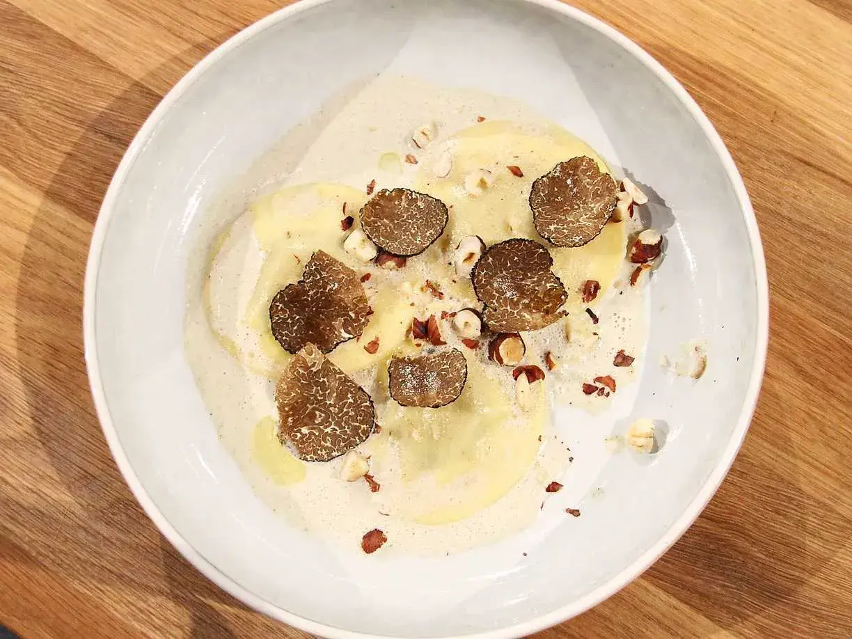 Ravioli med lyxig ravioli fyllning, toppad med tryffel och hasselnötter i krämig sås.
