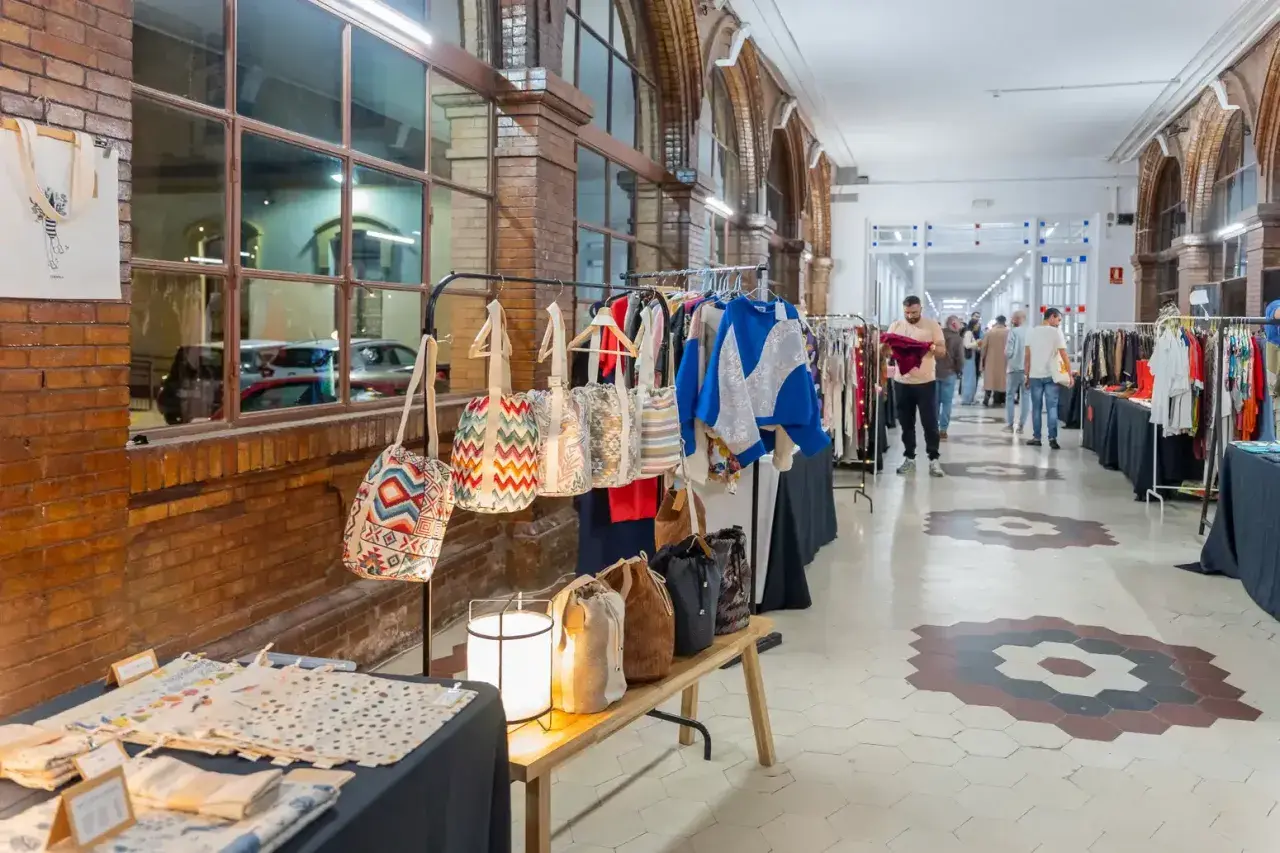Mercado de artesanía con bolsos coloridos y ropa, evocando las tradiciones de Málaga.