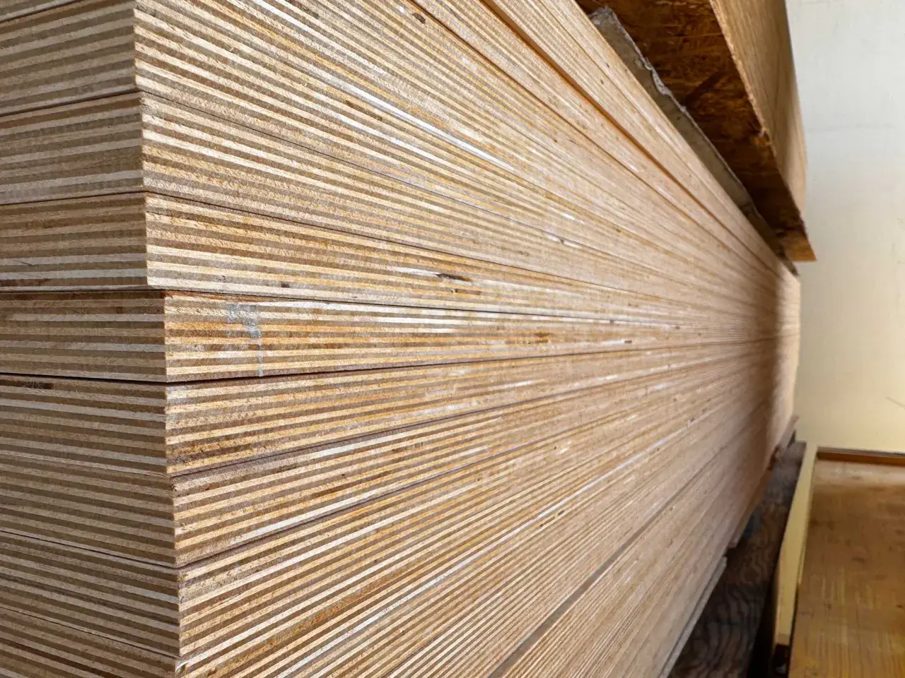 Una pila de maderas blancas, con sus finas capas visibles, listas para ser transformadas en muebles o estructuras.