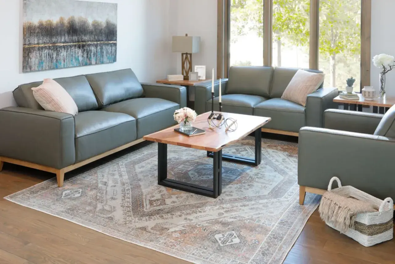 A modern living room with grey leather sofas, a live-edge coffee table, and a Persian-style rug, perfect for a furniture style guide.