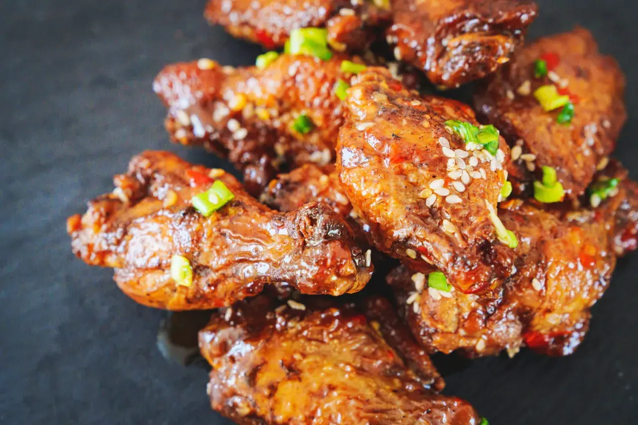 Ailes de poulet croustillantes, nappées d'une sauce sucrée et salée, garnies de graines de sésame et de ciboule. Un délice de marinade poulet.