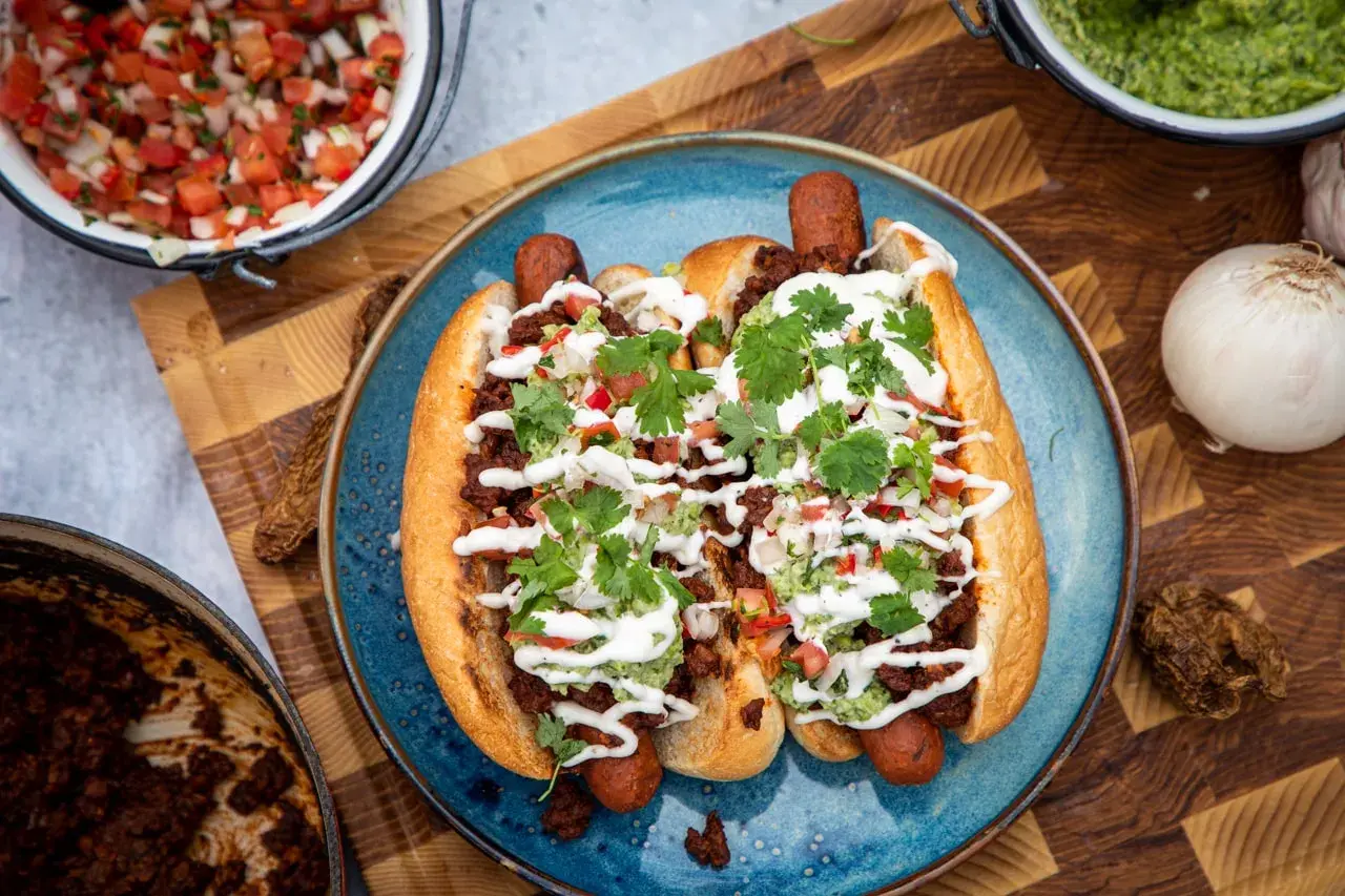 Två lyxiga korvar i bröd med chili, guacamole och en fräsch pico de gallo. Perfekt för en festlig måltid!