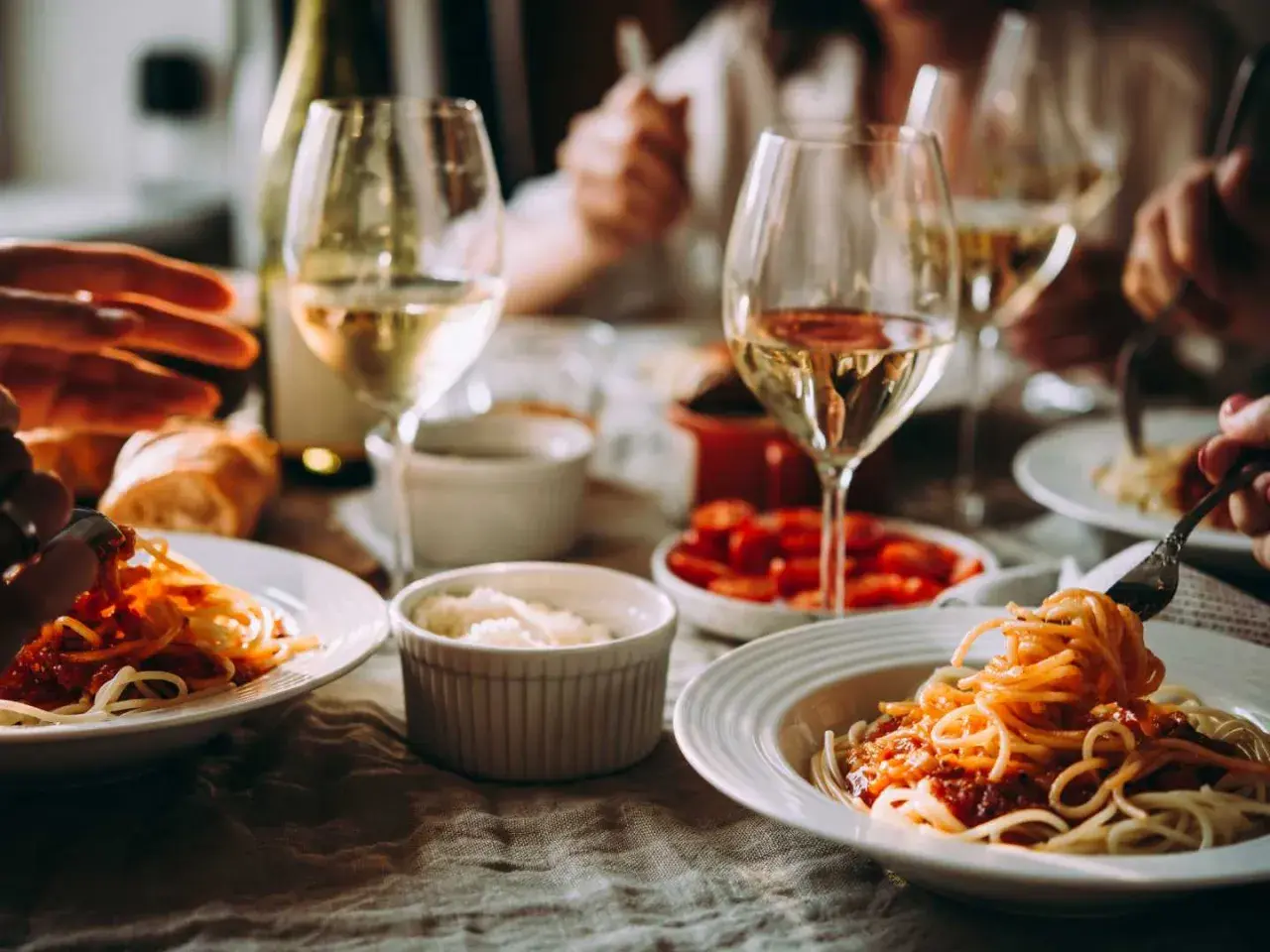 En härlig middag med spaghetti och tomatsås, perfekt som middagstips vardag. Glas med vitt vin och bröd kompletterar måltiden.