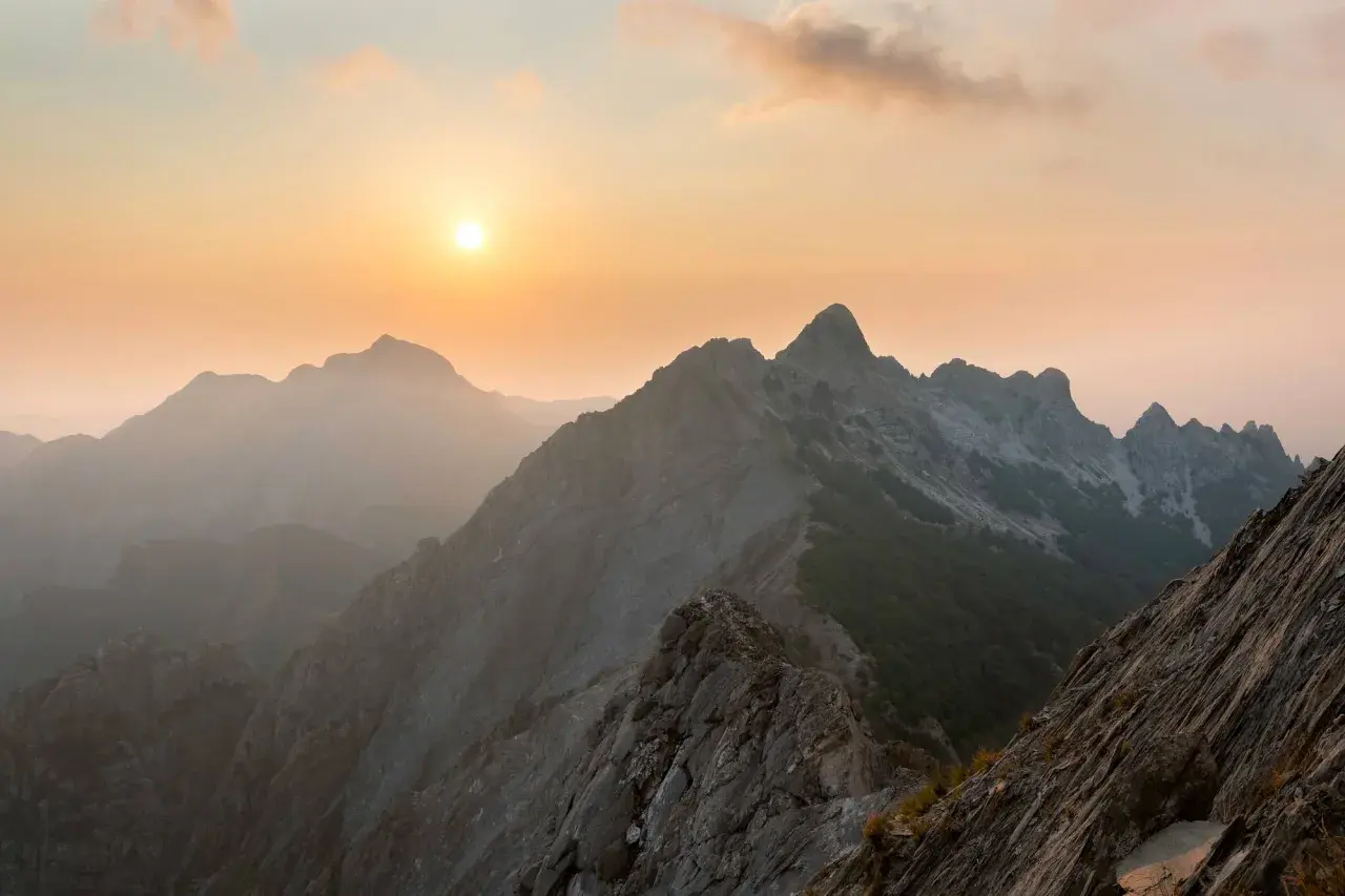 Albe rosate sulle Alpi Apuane, dove sono queste maestose vette rocciose che si stagliano contro il cielo al tramonto.