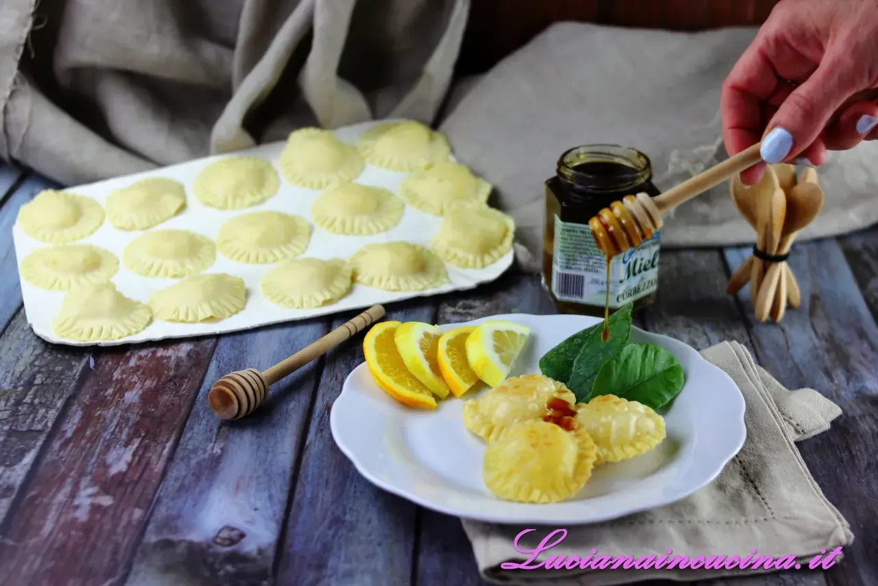 Seadas pronte per essere fritte, con miele, limone e arancia come ingredienti.