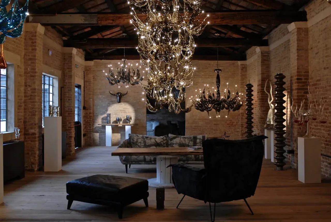 Interno con lampadari di cristallo e arredi moderni. Un'opera di Fabio Fornasier illumina l'ambiente.