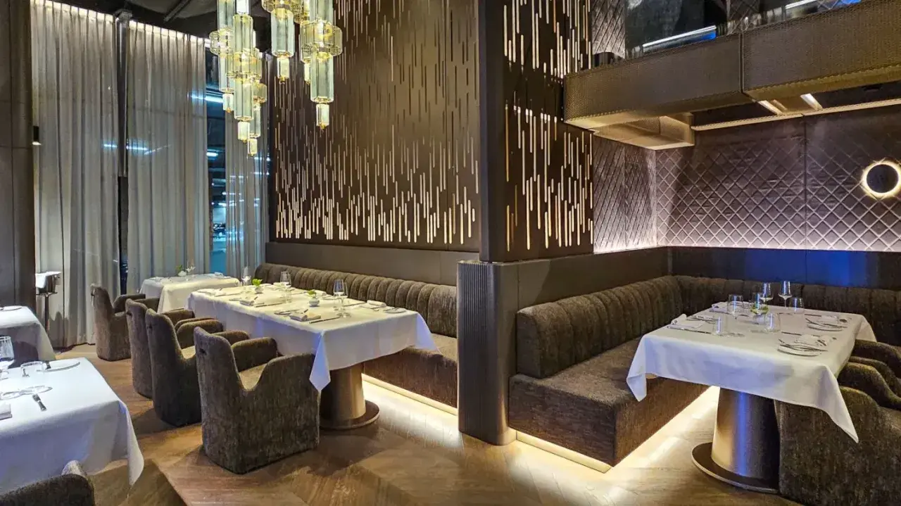 Eleganckie wnętrze restauracji w Poznaniu, z białymi obrusami i nowoczesnym designem. Idealne miejsce na odkrycie nowych restauracji w Poznaniu.