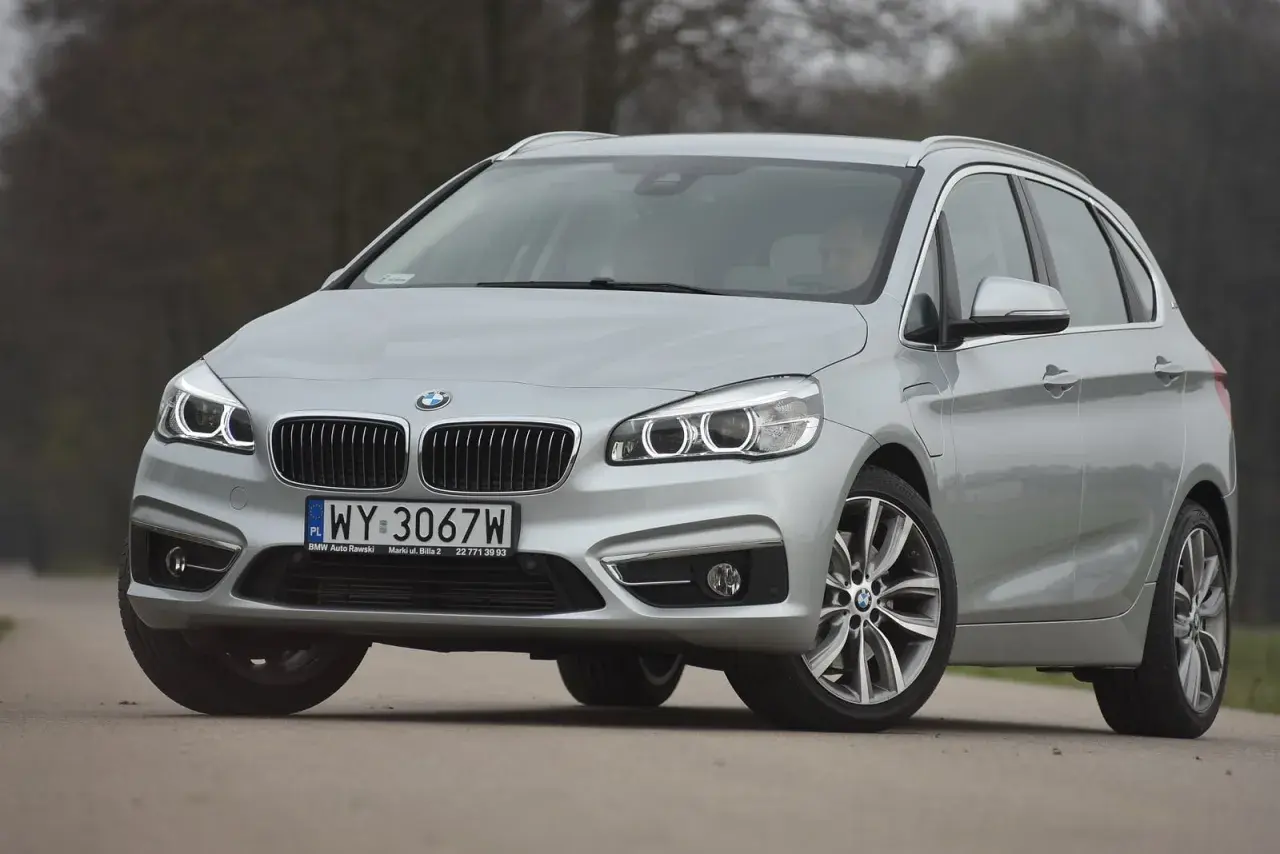 Srebrne bmw 218i na drodze, z przodu widoczna atrapa chłodnicy i reflektory.