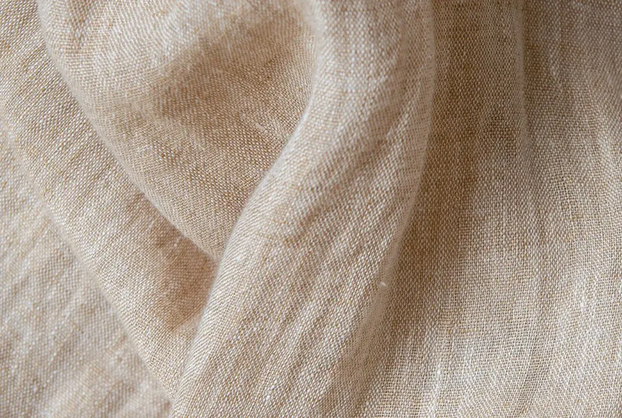Texture naturelle du lin, évoquant la douceur et la qualité de sa fabrication.