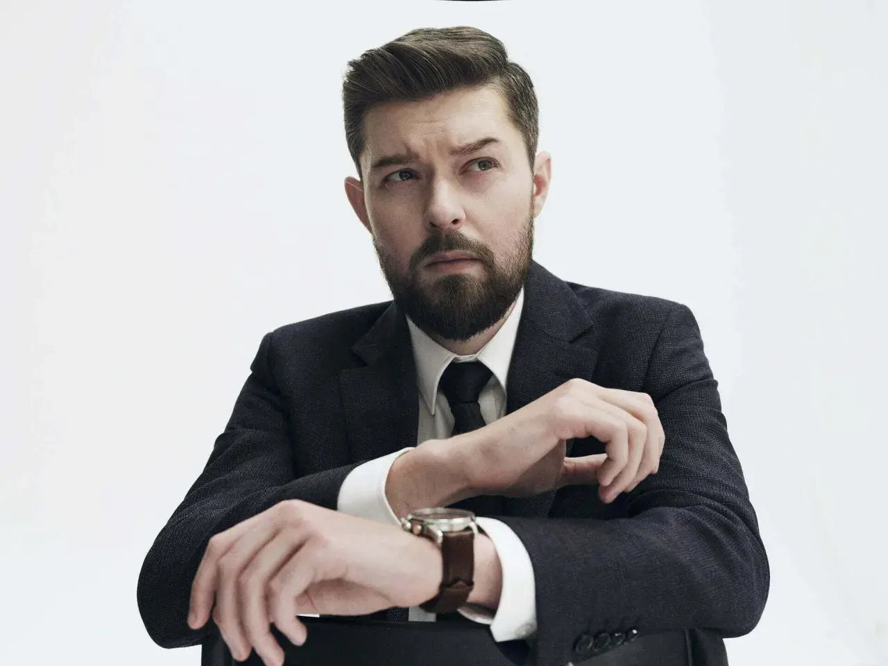 Remigiusz Mróz, znany pisarz, w eleganckim garniturze, z zamyśloną miną. Może planuje kolejną premierę książki, a może wizytę u dentysty?