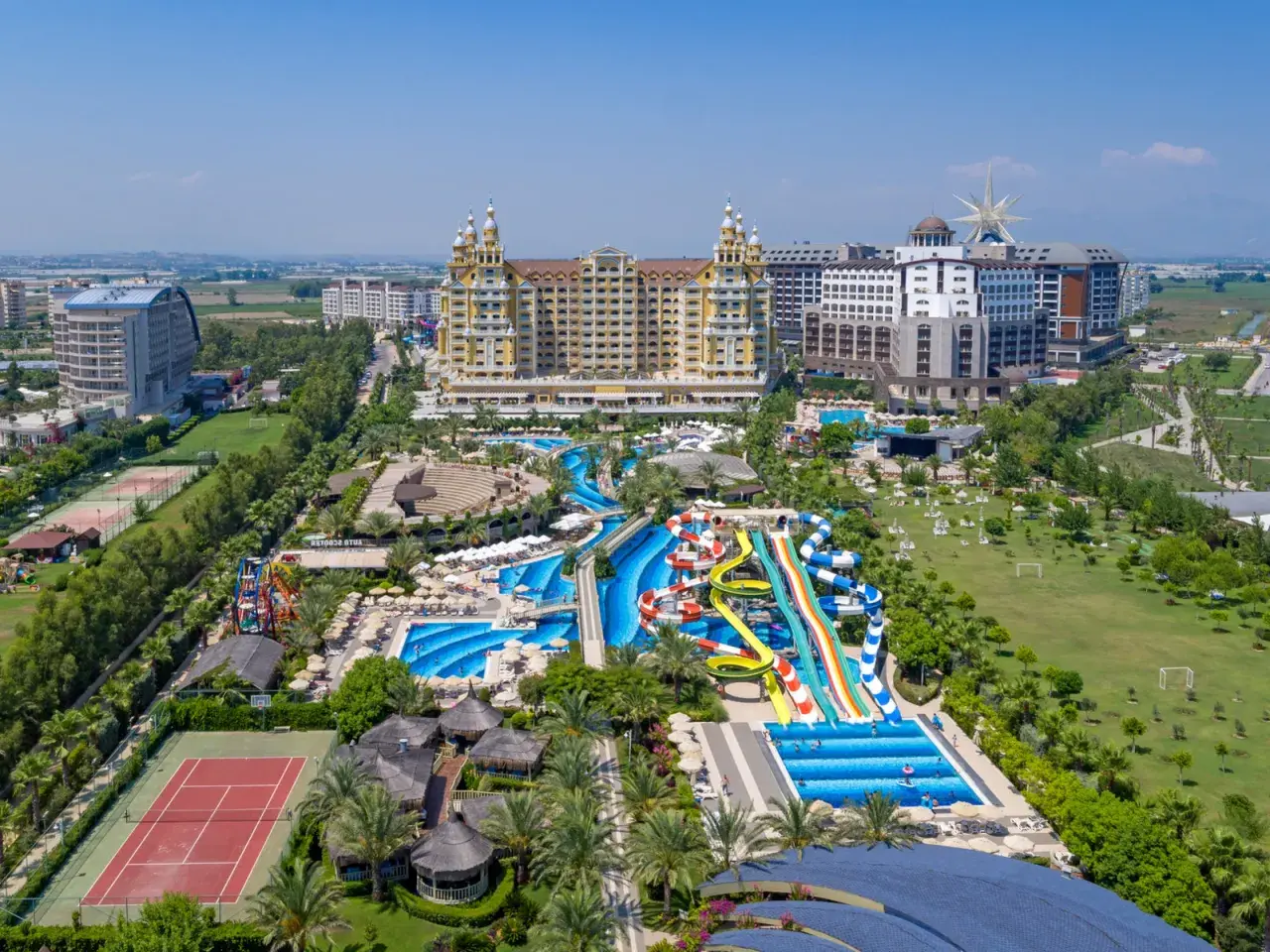 Ein luxuriöser royal holiday palace mit Wasserrutschen, Pools, Tennisplätzen und viel Grün.