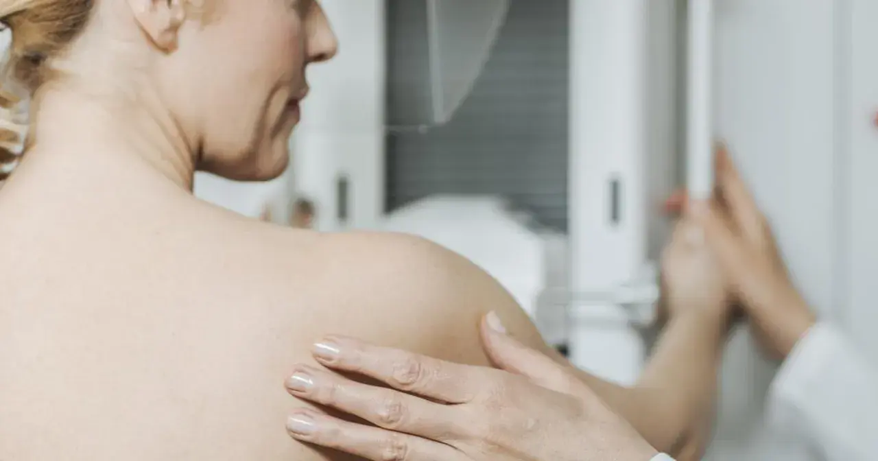 Kobieta podczas mammografii. Badanie to jest kluczowe w diagnostyce raka piersi, a leczenie często obejmuje tamoxifen.