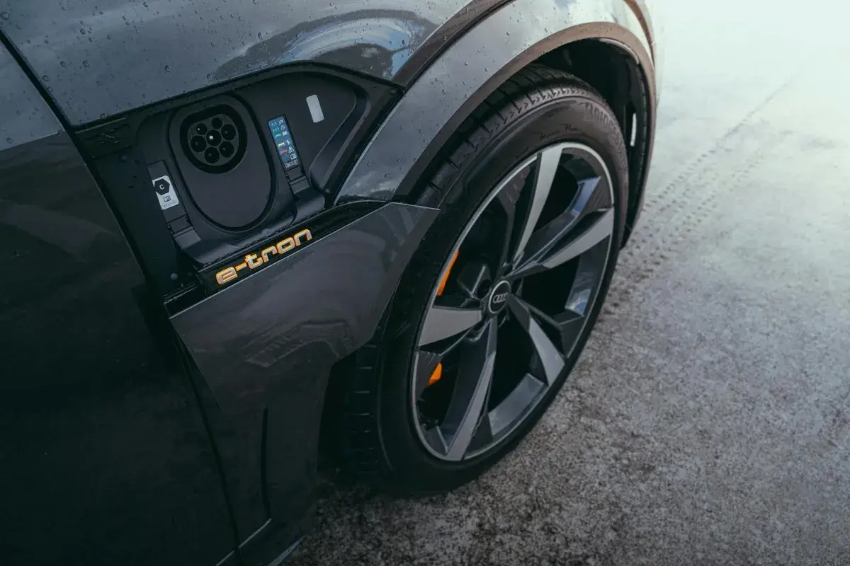Zbliżenie na port ładowania i felgę Audi A3 e-tron. Elektryczna mobilność w nowoczesnym wydaniu.
