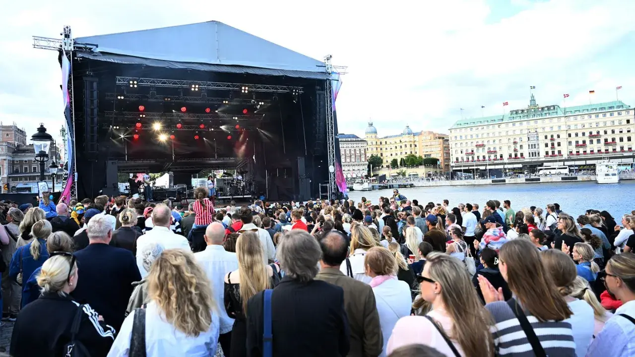 Stor publik njuter av en utomhuskonsert vid vattnet under ett kultur festival.