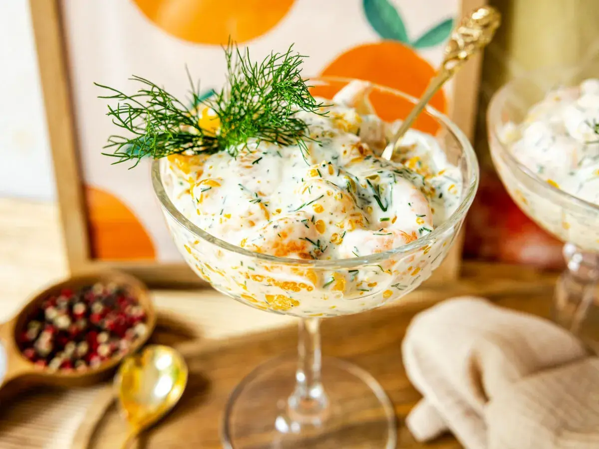 Erfrischender Krabbencocktail mit süßen Mandarinenstücken, cremiger Sauce und Dill garniert.