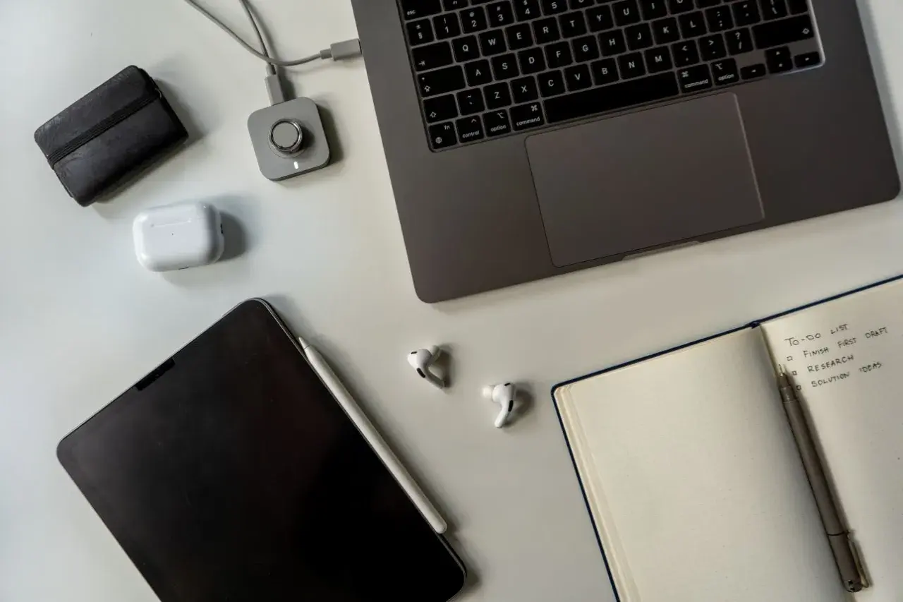 Staż pracy umowa zlecenie: laptop, tablet, słuchawki i notatnik z listą zadań.