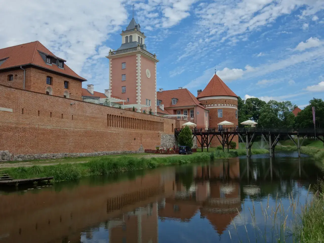 Zamek w Lidzbarku Warmińskim, z wieżą i fosą, to jedna z głównych atrakcji regionu.