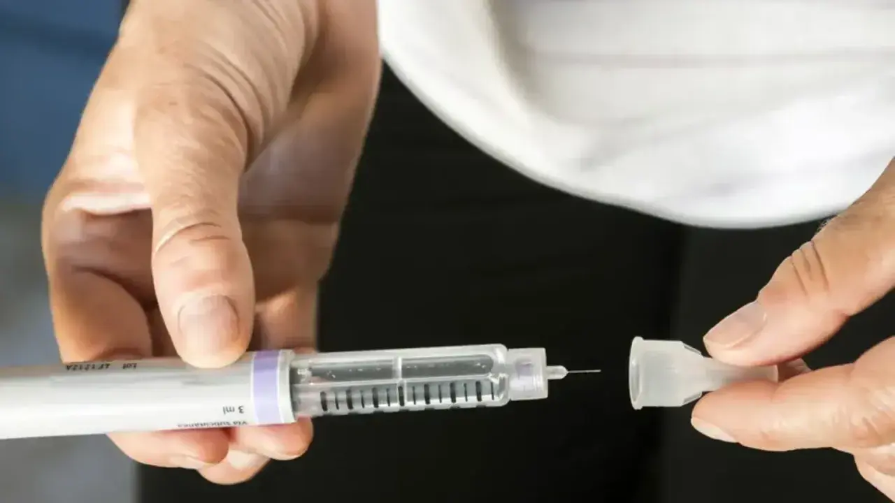 Dłoń przygotowuje pen do podania insuliny, kluczowy element w leczeniu cukrzycy typu 2.